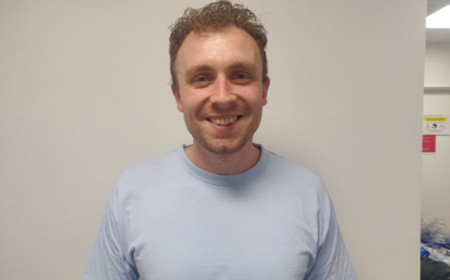 27-årig mandlig sygeplejerske står og smiler