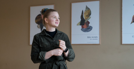 Julie Renee Jensen står foran en væg med billeder