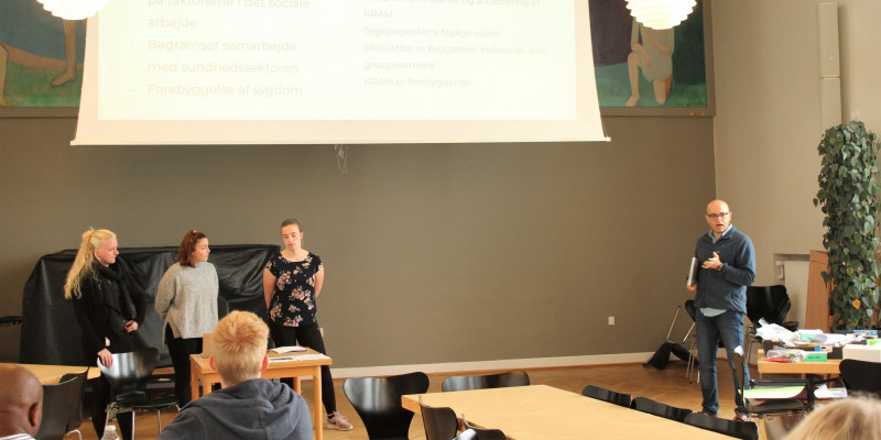 Socialrådgiverstuderende Michelle Pauline Petersen Thaysen, sygeplejerskestuderende Jeanette Eskildsen,  fysioterapeutstuderende Lea Agertoft og sygeplejerskestuderende Mohammadreza Aghanassir fremlægger deres projekt om KRAM-faktorer Studerende fremlægger