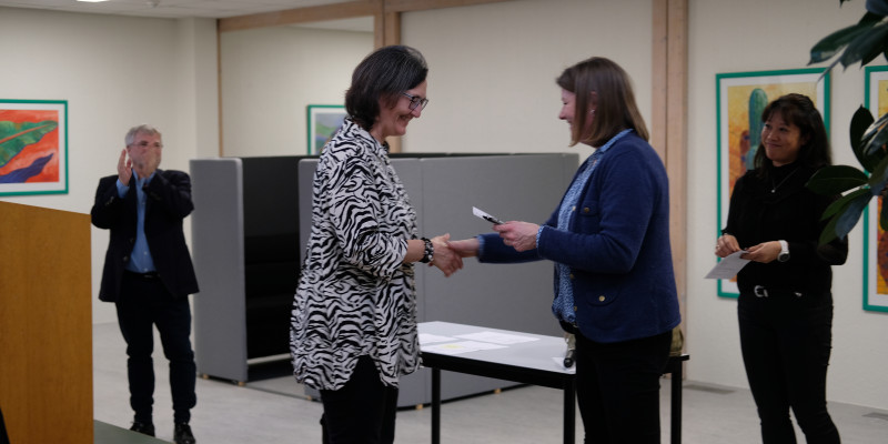 Faglig leder Lone Holst overrækker en dimissionsgave til en dimittend på pædagogisk diplom