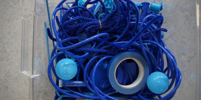 Blå ledninger, bånd, snorre og bolde i en kasse