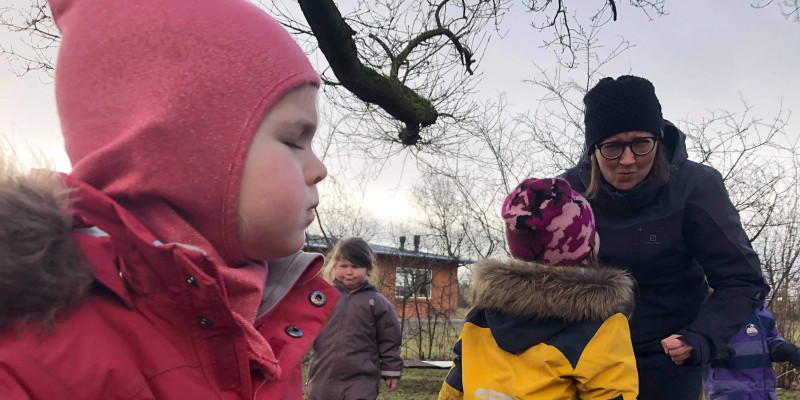 Børnene og Mette Nielsen fra Resen Naturbørnehave viser, hvordan en sur trold kan se ud.